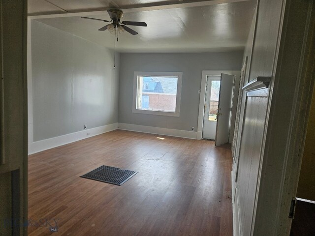 interior space featuring wood finished floors, a ceiling fan, visible vents, and baseboards