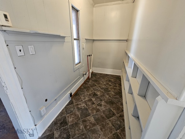 clothes washing area featuring stone finish floor and baseboards