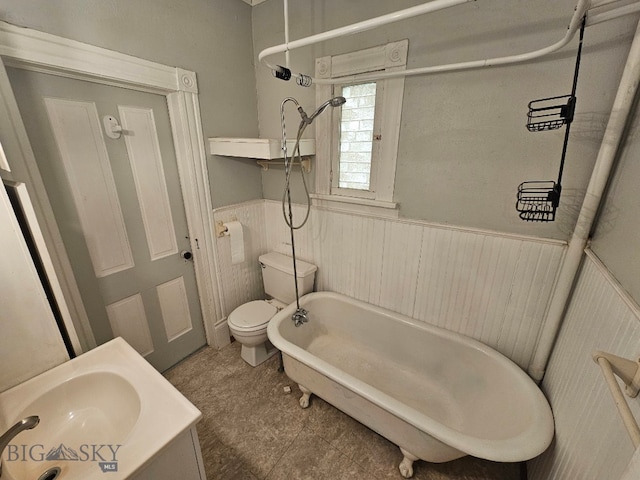 full bathroom with a sink, a shower, a tub to relax in, a wainscoted wall, and toilet
