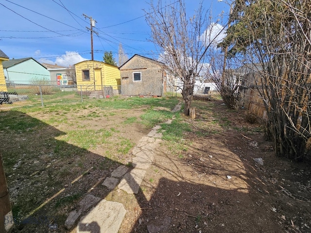 view of yard with fence and an outbuilding