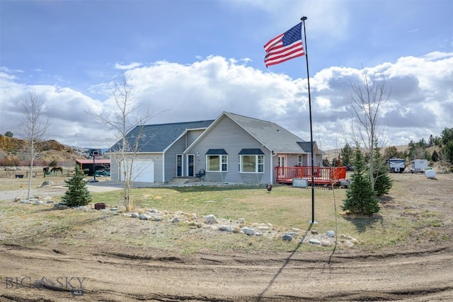 view of front facade featuring a front yard, a garage, a wooden deck, driveway, and roof with shingles