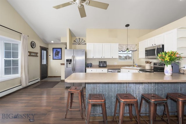 kitchen featuring stainless steel appliances, a peninsula, dark wood-style floors, and white cabinetry