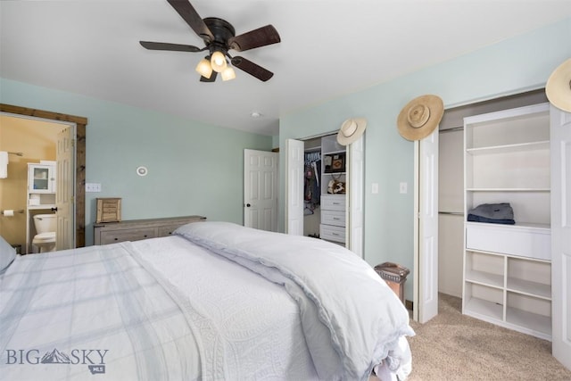carpeted bedroom with ensuite bathroom and a ceiling fan