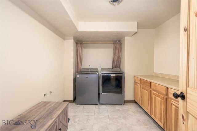 clothes washing area featuring cabinet space and washing machine and clothes dryer