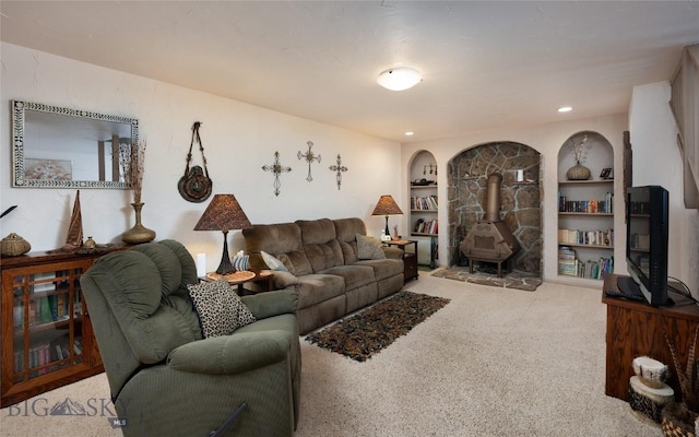 carpeted living area featuring a wood stove, built in shelves, and recessed lighting