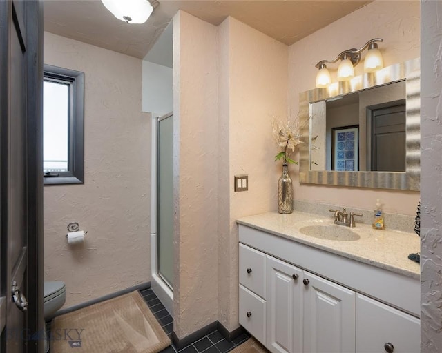 full bath with a stall shower, vanity, baseboards, and tile patterned flooring