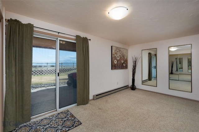 carpeted spare room with baseboard heating and baseboards