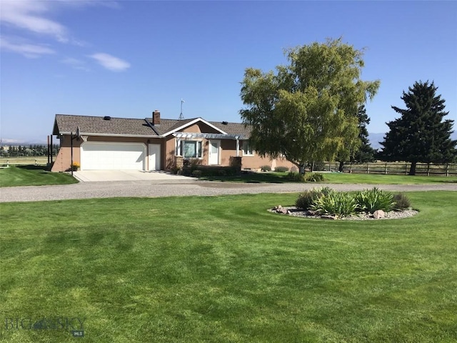ranch-style home with a front yard, an attached garage, fence, stucco siding, and curved driveway
