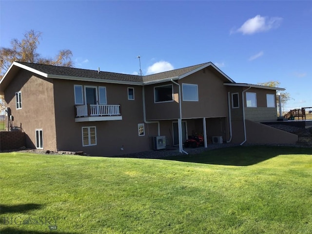 rear view of property with a yard and stucco siding