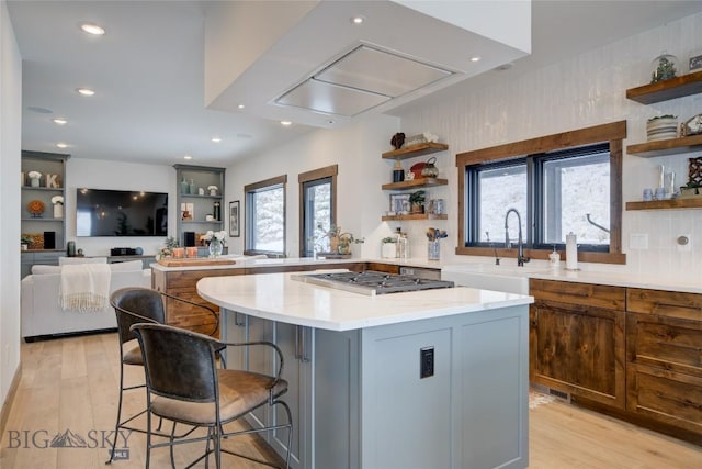 280 High Ridge Rd, Bozeman, MT 59715 - kitchen with stainless steel gas cooktop, a kitchen bar, open shelves, and light wood-style floors