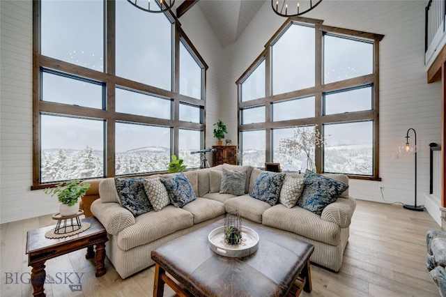 280 High Ridge Rd, Bozeman, MT 59715 - living room with light wood-style flooring, a high ceiling, wooden walls, and a notable chandelier