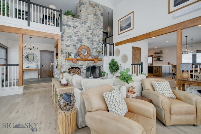 280 High Ridge Rd, Bozeman, MT 59715 - living area with a chandelier, wood finished floors, a high ceiling, and a stone fireplace