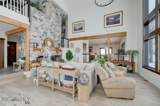 280 High Ridge Rd, Bozeman, MT 59715 - living area with visible vents, wood finished floors, a chandelier, and a towering ceiling