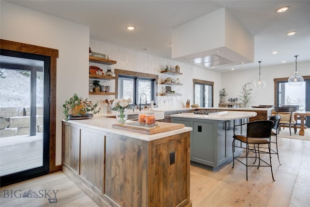 280 High Ridge Rd, Bozeman, MT 59715 - kitchen with gray cabinets, a peninsula, light countertops, open shelves, and a kitchen bar