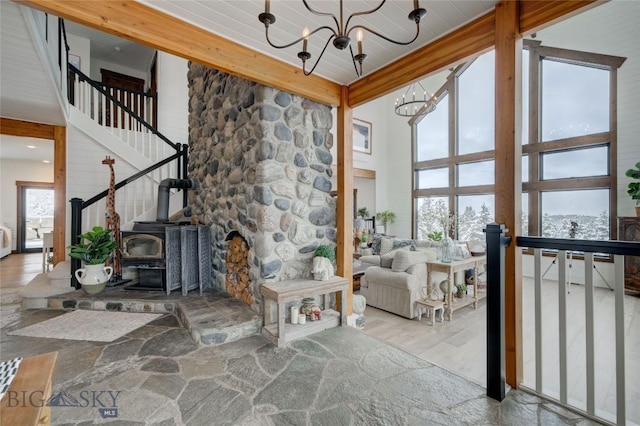 280 High Ridge Rd, Bozeman, MT 59715 - living room featuring a wood stove, a towering ceiling, a chandelier, and wood finished floors