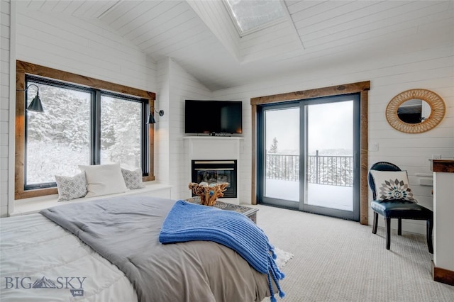 280 High Ridge Rd, Bozeman, MT 59715 - bedroom with vaulted ceiling with skylight, access to exterior, a glass covered fireplace, and carpet floors
