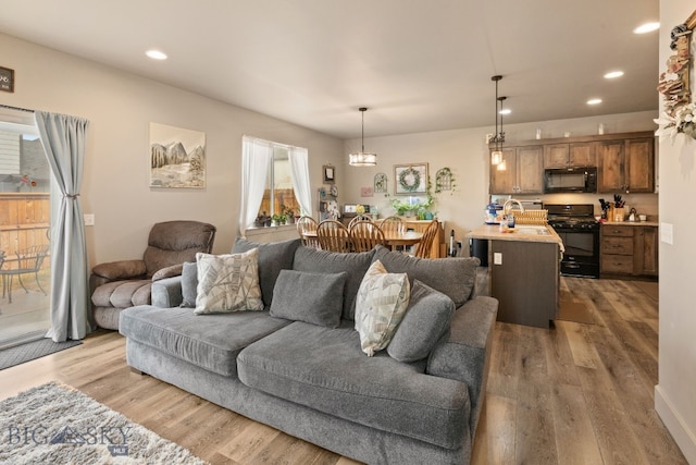 1519 Butler Crk Unit B, Belgrade, MT 59714 - living area featuring light wood finished floors, recessed lighting, and a chandelier