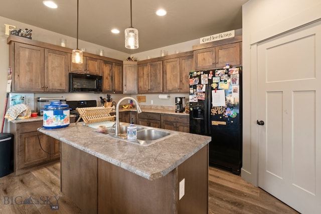 1519 Butler Crk Unit B, Belgrade, MT 59714 - kitchen with black appliances, a sink, wood finished floors, light countertops, and hanging light fixtures