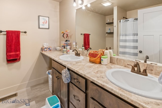 1519 Butler Crk Unit B, Belgrade, MT 59714 - full bathroom with double vanity, wood finished floors, baseboards, and a shower with shower curtain