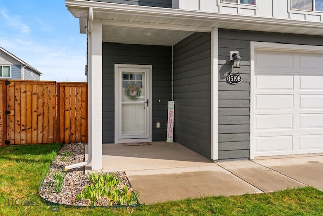 1519 Butler Crk Unit B, Belgrade, MT 59714 - view of exterior entry featuring fence, board and batten siding, and a garage