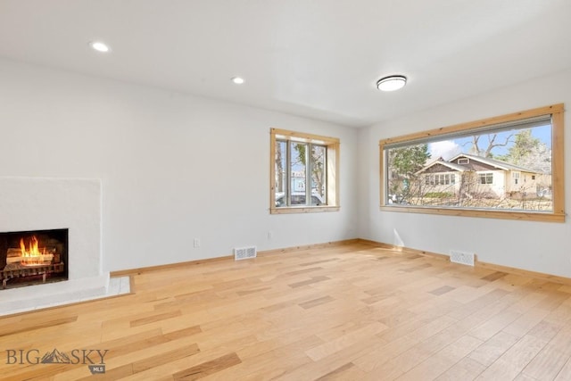 614 S 6th, Bozeman, MT 59715 - unfurnished living room with plenty of natural light, visible vents, baseboards, and wood finished floors