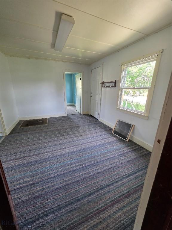201 S Brooke St, Whitehall, MT 59759 - carpeted empty room featuring baseboards