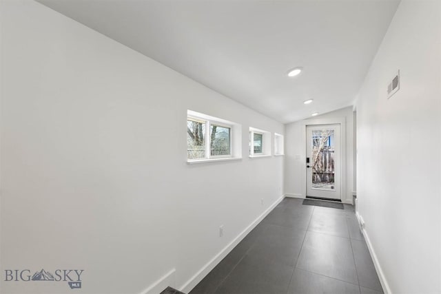 doorway with dark tile patterned flooring, baseboards, recessed lighting, and vaulted ceiling