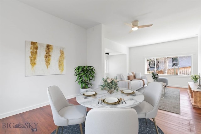 dining space with wood finished floors, ceiling fan, and baseboards