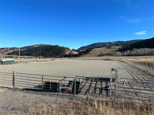 view of yard featuring a mountain view, fence, and a rural view