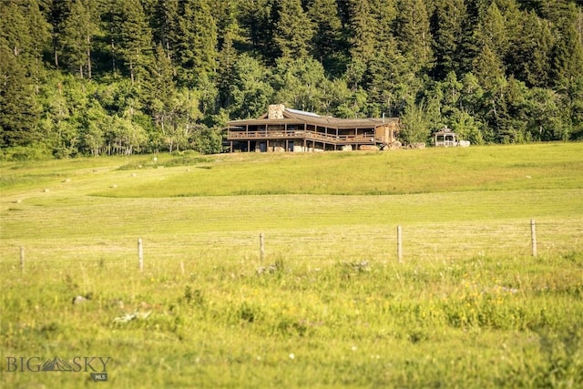 birds eye view of property featuring a wooded view and a rural view