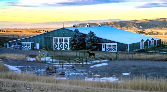 view of front of house featuring an outbuilding, a mountain view, and an exterior structure