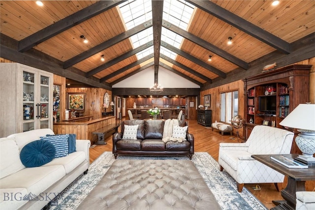living room with wooden walls, beamed ceiling, and wood finished floors