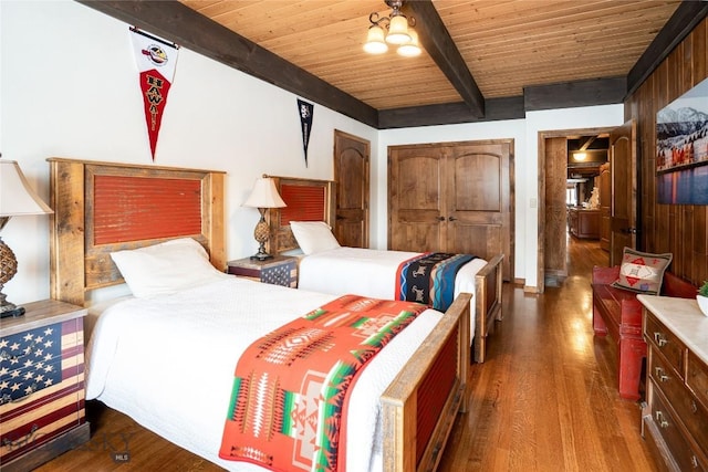 bedroom featuring wooden ceiling, beamed ceiling, a ceiling fan, and wood finished floors