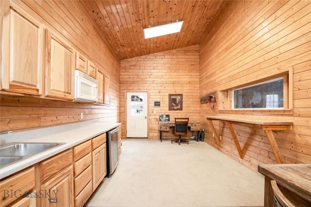 interior space with wooden walls, high vaulted ceiling, concrete floors, and a sink
