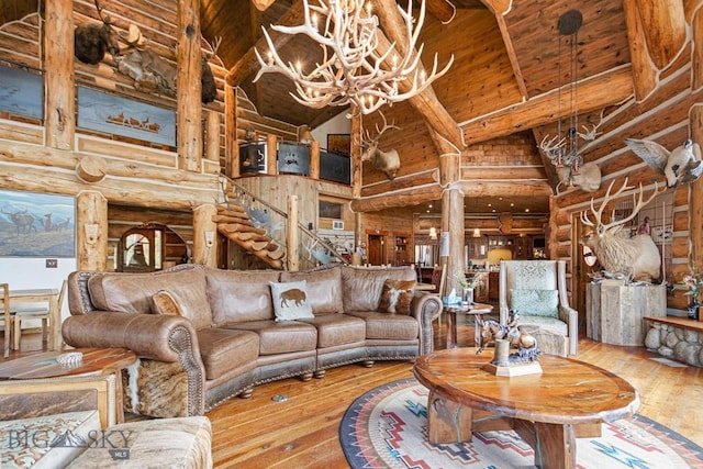 569/571 Cinnabar Basin Rd, Gardiner, MT 59030 - living room with high vaulted ceiling, hardwood / wood-style flooring, beamed ceiling, log walls, and a chandelier