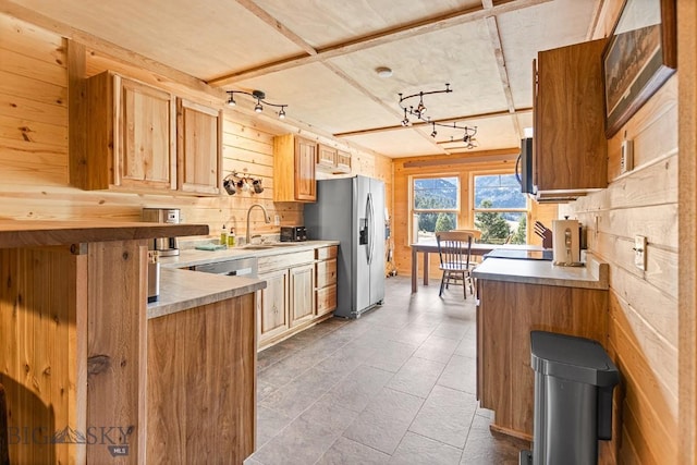 569/571 Cinnabar Basin Rd, Gardiner, MT 59030 - kitchen with stainless steel appliances, a sink, light countertops, and wood walls
