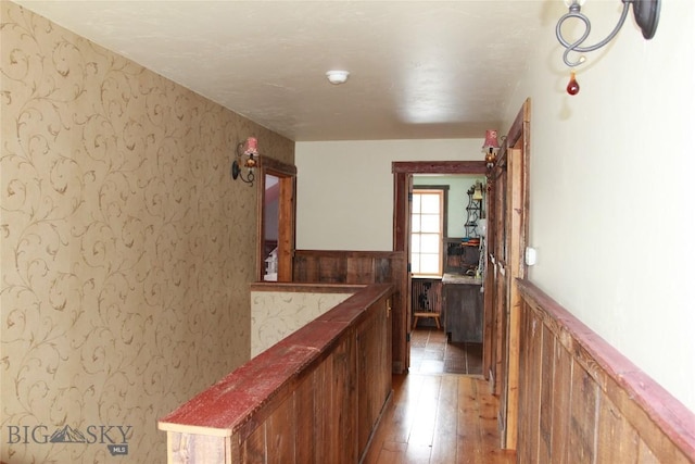 569/571 Cinnabar Basin Rd, Gardiner, MT 59030 - hallway featuring light wood finished floors, wainscoting, and wallpapered walls