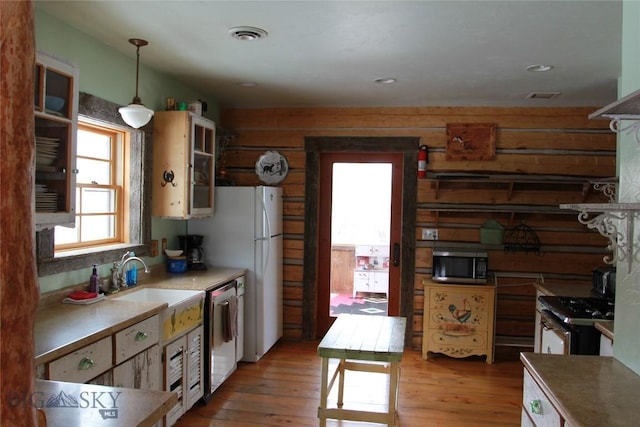 569/571 Cinnabar Basin Rd, Gardiner, MT 59030 - kitchen with appliances with stainless steel finishes, light wood finished floors, hanging light fixtures, and a sink