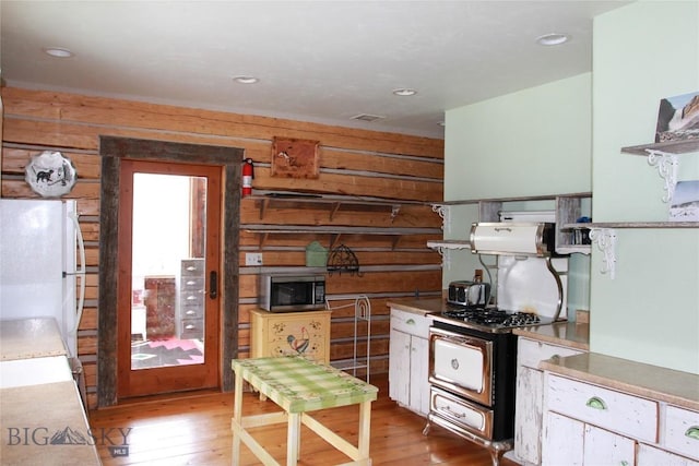 569/571 Cinnabar Basin Rd, Gardiner, MT 59030 - kitchen with stainless steel microwave, light wood-style flooring, freestanding refrigerator, gas range oven, and recessed lighting