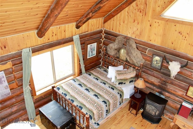 569/571 Cinnabar Basin Rd, Gardiner, MT 59030 - bedroom with multiple windows, a wood stove, wood ceiling, hardwood / wood-style floors, and beamed ceiling
