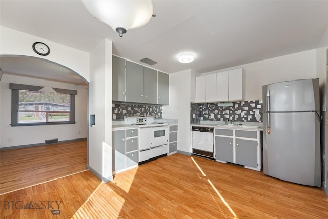 1814 Hamburg Ave, Anaconda, MT 59871 - kitchen featuring white appliances, arched walkways, light countertops, and light wood-style flooring