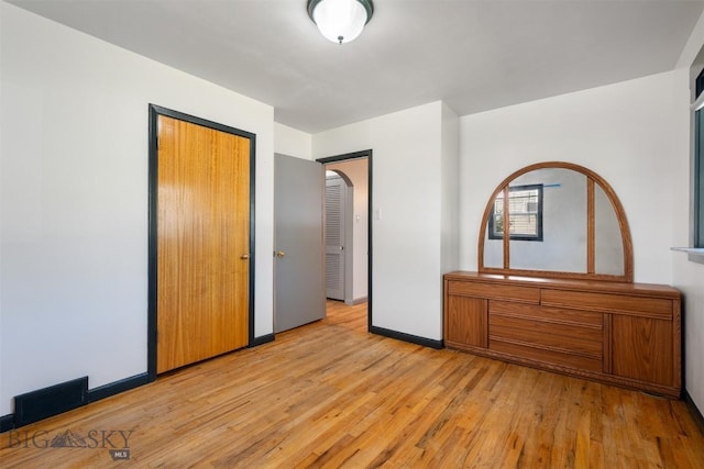 1814 Hamburg Ave, Anaconda, MT 59871 - unfurnished bedroom with light wood-style floors, arched walkways, and a closet