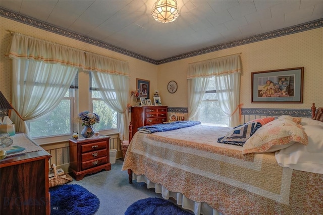 carpeted bedroom featuring crown molding, multiple windows, and wallpapered walls