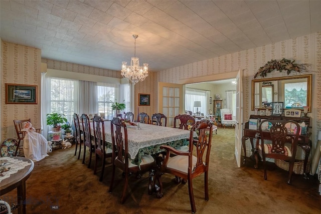 dining space featuring an inviting chandelier, carpet, and wallpapered walls