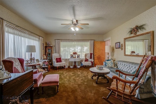 carpeted living area featuring a wealth of natural light, a ceiling fan, and wallpapered walls