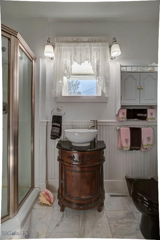 bathroom with a wainscoted wall, marble finish floor, and vanity
