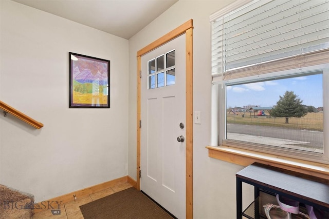 tiled foyer entrance with baseboards