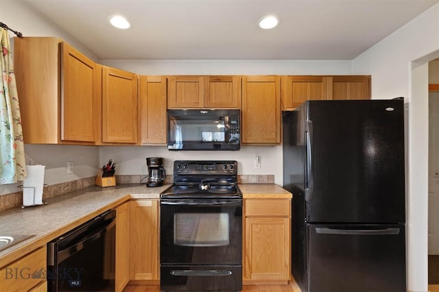 kitchen featuring light countertops, black appliances, and recessed lighting