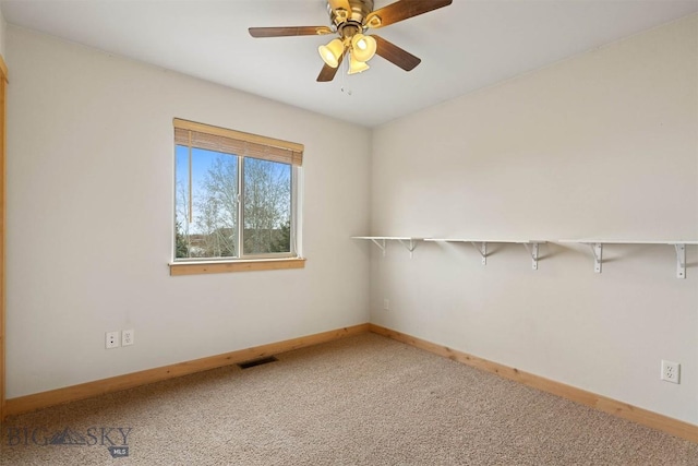 carpeted empty room with ceiling fan, baseboards, and visible vents