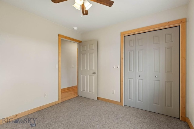 unfurnished bedroom with ceiling fan, a closet, carpet flooring, and baseboards